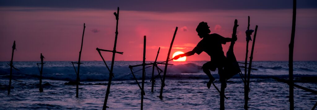 En bild på en fiskare i solnedgången